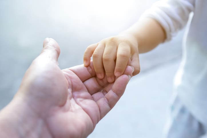 Trimnal & Myers, iimage of parent holding baby hand